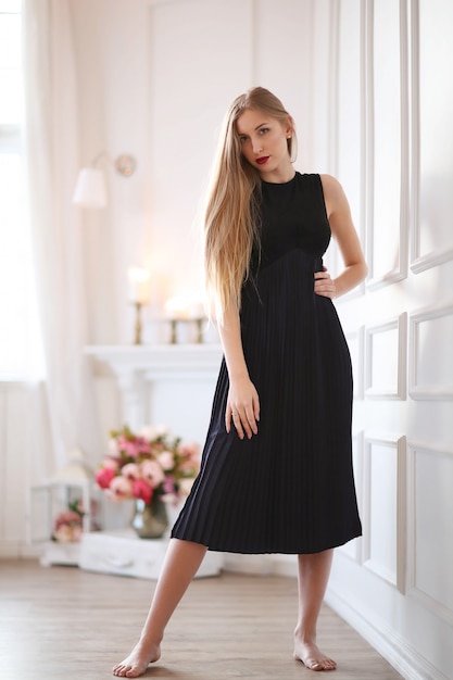 Mode jeune femme posant avec une robe noire