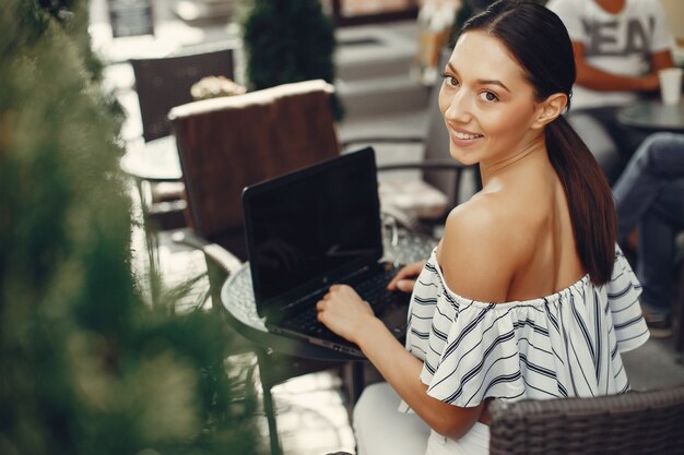 Mode jeune fille assise dans un café d&#39;été