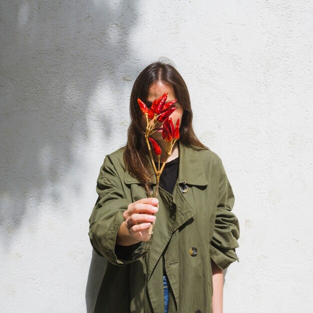 Mode moyen coup femme couvrant son visage avec un bouquet de poivrons