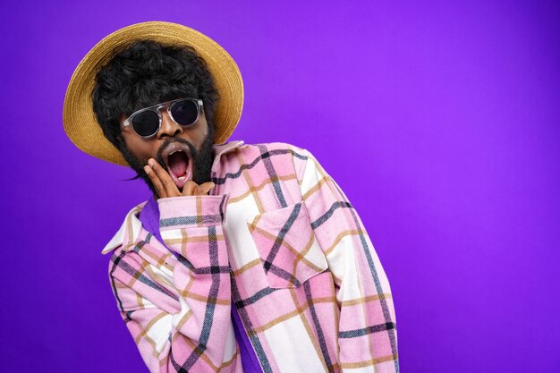 Mode portrait d'un homme afro-américain dans des verres sur fond violet