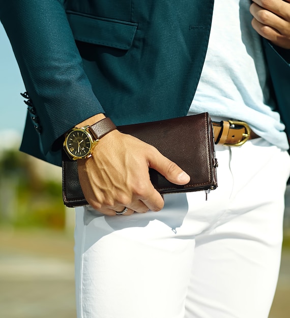 Mode portrait de jeune homme d'affaires beau modèle homme en costume de tissu décontracté avec accessoires sur les mains