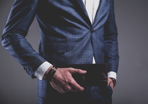 Mode portrait de jeune homme d'affaires beau modèle homme habillé en élégant costume bleu sur fond gris