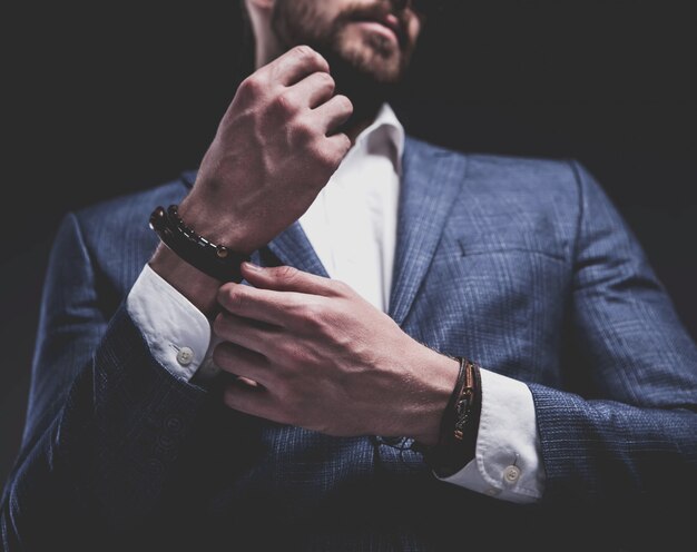 Mode portrait de jeune homme d'affaires beau modèle homme habillé en élégant costume bleu sur fond gris