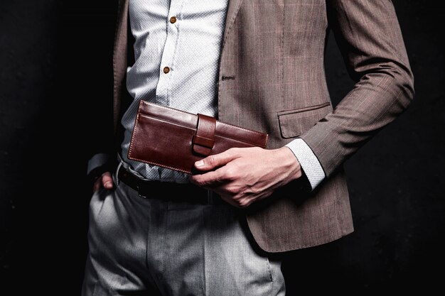 Mode portrait de jeune homme d'affaires beau modèle homme habillé en élégant costume marron avec accessoires