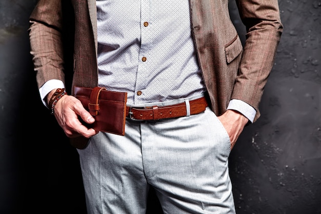 Mode portrait de jeune homme d'affaires beau modèle homme habillé en élégant costume marron avec accessoires