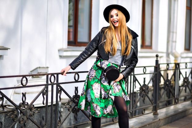 Photo gratuite mode portrait de style de rue de jolie femme avec de longs cheveux blonds incroyables, une tenue mignonne élégante, une jupe longue vintage, un chapeau élégant et une veste de motard, centre-ville européen, voyageur élégant, modèle.