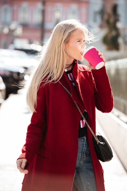 Mode sérieuse jeune femme blonde marchant à l'extérieur