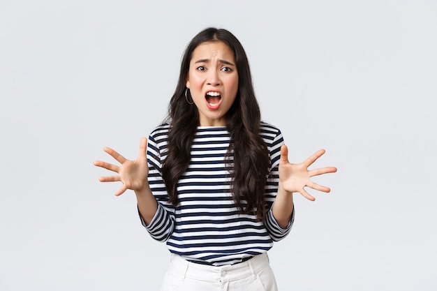 Mode de vie, émotions des gens et concept décontracté. Femme asiatique panique en panique, gesticulant se plaignant et ayant l'air ennuyée, Fille perdant son sang-froid après une journée de contact au travail, ayant d'énormes problèmes