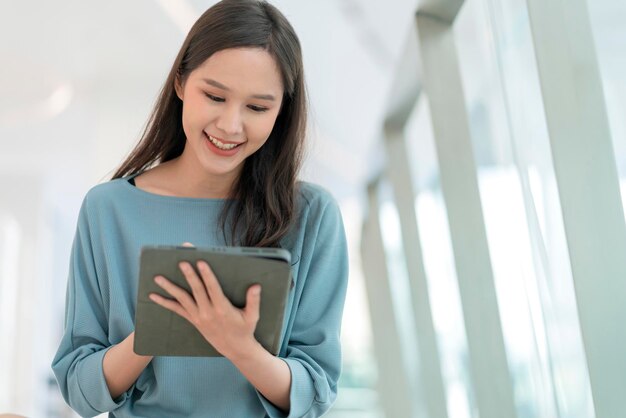 Mode de vie nomade numérique main de femme asiatique à l'aide d'une tablette travaillant tout en restant à l'extérieur avec la lumière naturelle