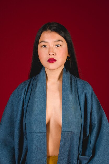 Modèle asiatique pose avec fond rouge