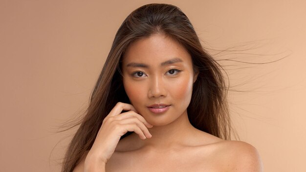 Modèle asiatique thaïlandais avec maquillage naturel sur fond beige