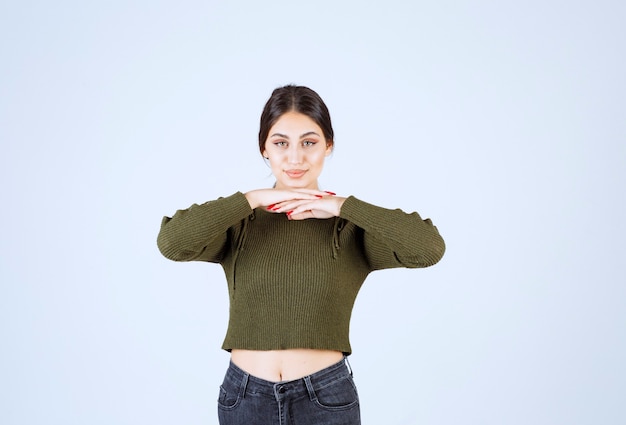 Photo gratuite un modèle de belle jeune femme en chemisier vert sur mur blanc