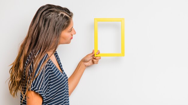 Modèle brune tenant cadre jaune