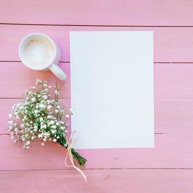 Modèle, café et bouquet au fond rose