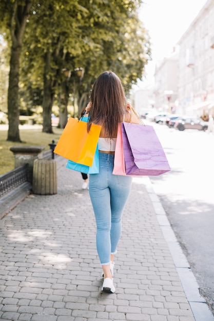 Modèle confiant avec des sacs marchant dans la rue