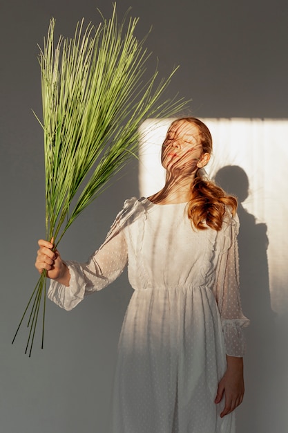 Photo gratuite modèle élégant posant avec plante