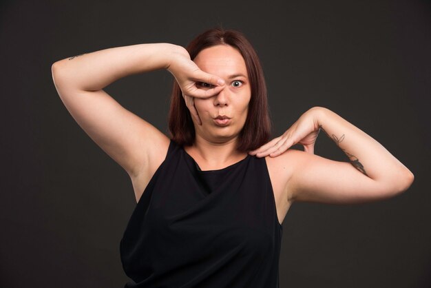 Modèle féminin en chemise noire faisant une pose effrayante.