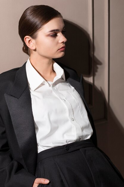 Modèle féminin élégant qui pose en studio en costume de veste. nouveau concept de féminité
