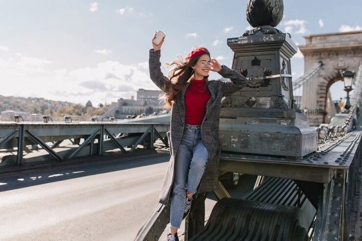 Photo gratuit modèle féminin inspiré porte des jeans vintage relaxant pendant la séance photo sur le pont
