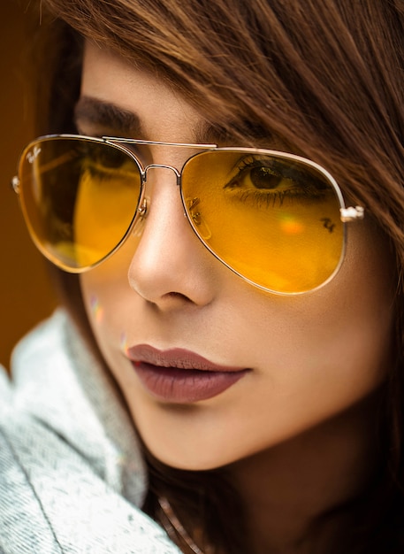 Modèle féminin avec des lunettes de soleil jaunes
