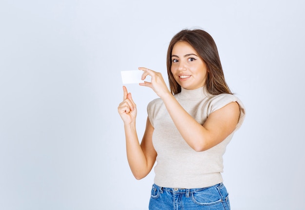 Un modèle de femme heureuse tenant une carte et posant.