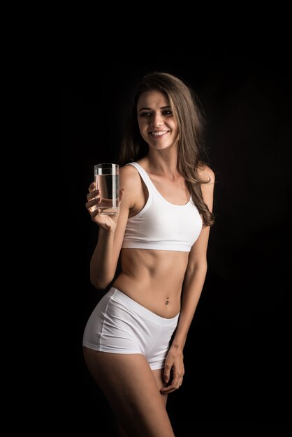 Modèle de fitness femme tenant un verre d&#39;eau