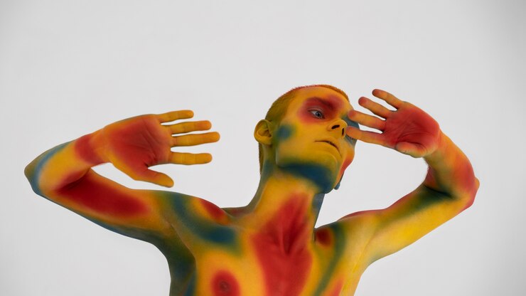 Photo gratuit modèle homme posant avec body painting coloré