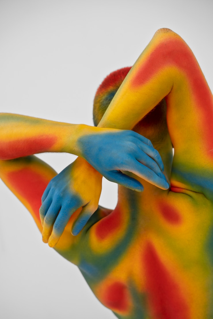Photo gratuit modèle homme posant avec body painting coloré