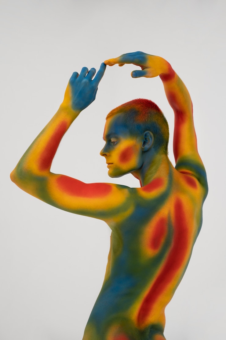 Photo gratuit modèle homme posant avec body painting coloré