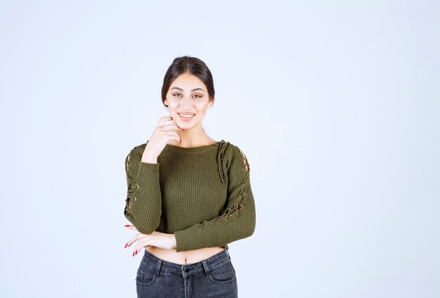 Un modèle de jeune femme charmante en vert bras debout croisés