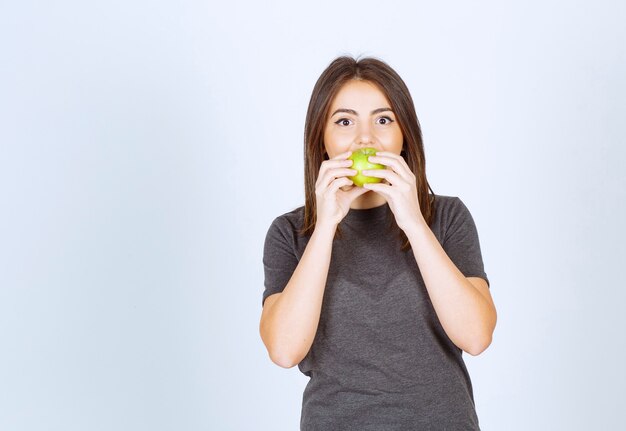 modèle de jeune femme mangeant une pomme verte.