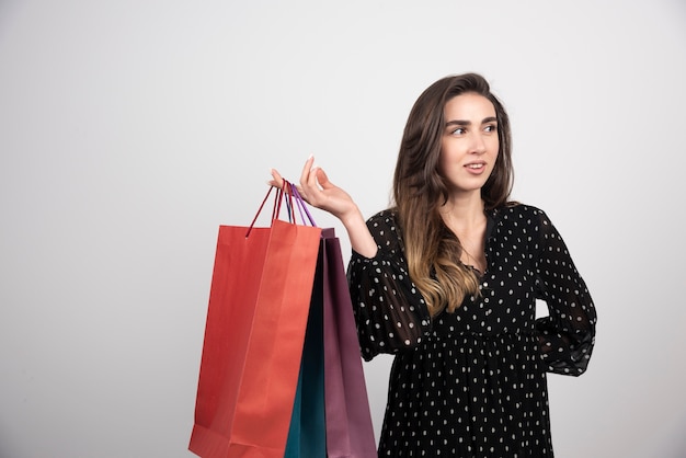 Modèle de jeune femme portant beaucoup de sacs à provisions