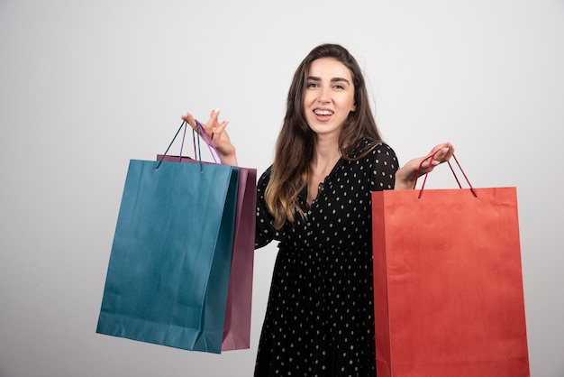 Modèle de jeune femme portant beaucoup de sacs à provisions