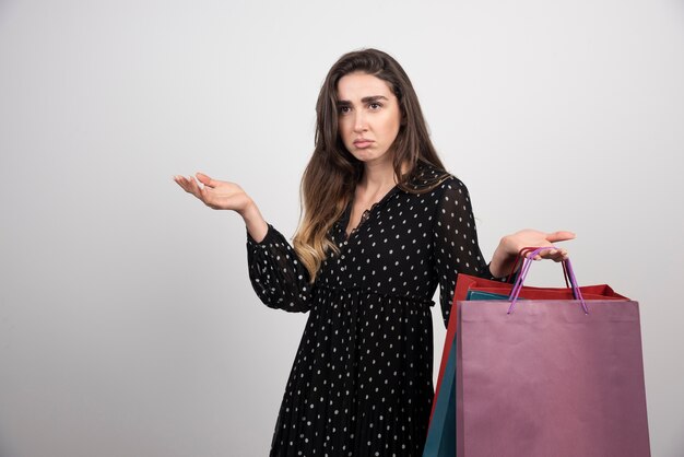 Modèle de jeune femme portant beaucoup de sacs à provisions