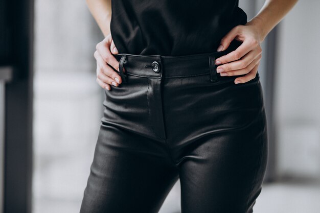 Modèle de jeune femme portant un pantalon en cuir noir