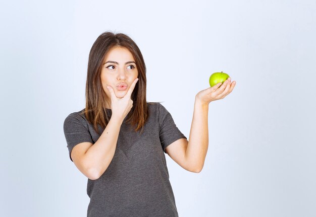 modèle de jeune femme tenant une pomme verte.