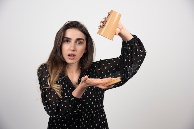 Modèle de jeune femme tenant une tasse de café vide