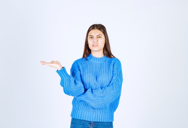 modèle de jeune fille en pull bleu montrant une main.