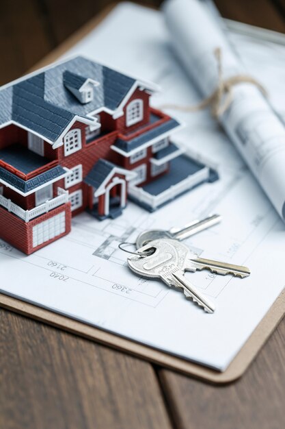 Modèle de maison de villa, clé et dessin sur rétro bureau (concept de vente immobilier)