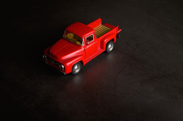 Modèle de pick-up rouge sur le sol noir