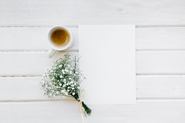 Modèle, tasse à café et bouquet de fleurs