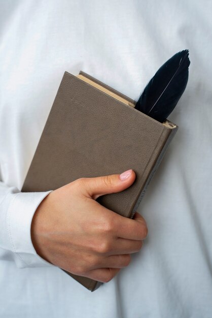 Modèle tenant un livre avec vue de face en plume