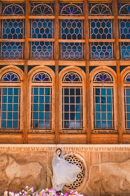 Modèle en tenue de prière devant une mosquée historique