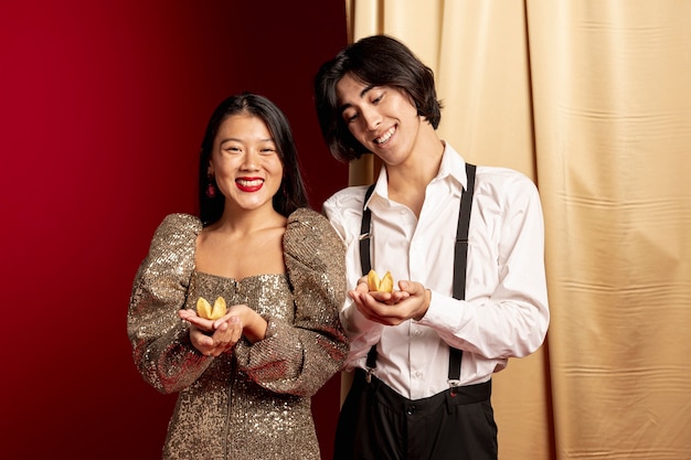 Photo gratuite modèles souriants tenant des biscuits de fortune pour le nouvel an chinois