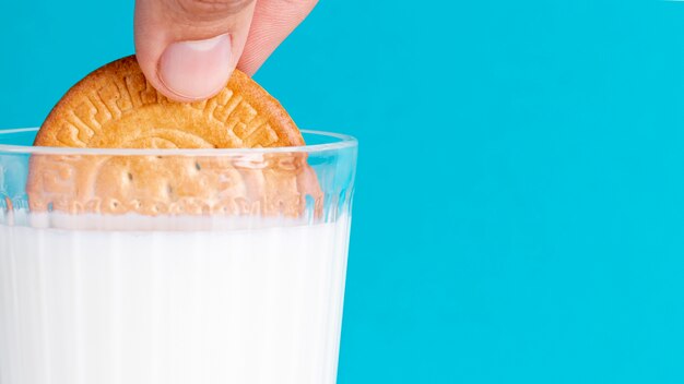 La moitié de biscuit trempé dans un verre de lait