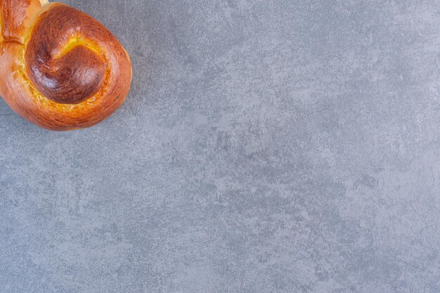 La moitié d'un petit pain sucré tourbillonnant sur fond de marbre. photo de haute qualité