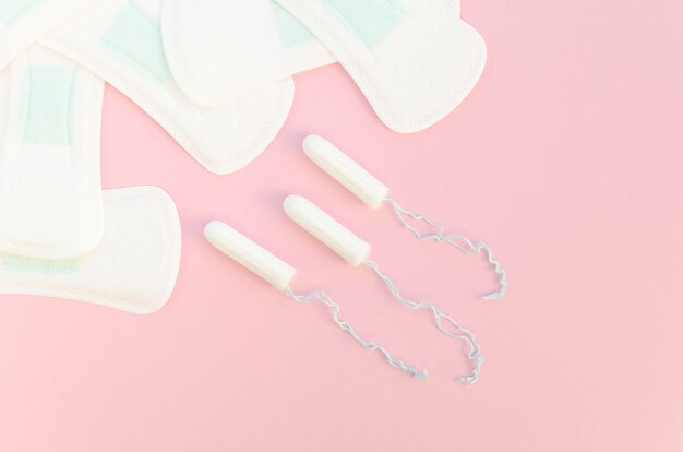 Moitiés de tampons et tampons sur fond rose