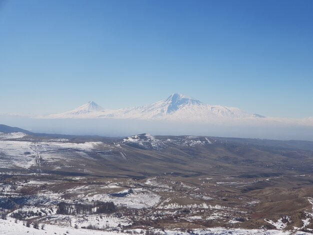 Le mont Ararat entouré de champs couverts de neige sous la lumière du soleil pendant la journée en Arménie