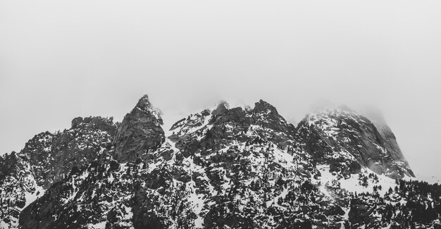 Montagne noire et blanche avec neige et brouillard