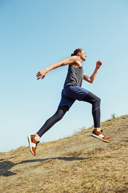 Monter la piste d'entraînement des athlètes masculins musclés en cours d'exécution pour le marathon